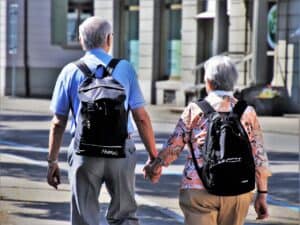 Older couple walking holding hands, how old to join AARP